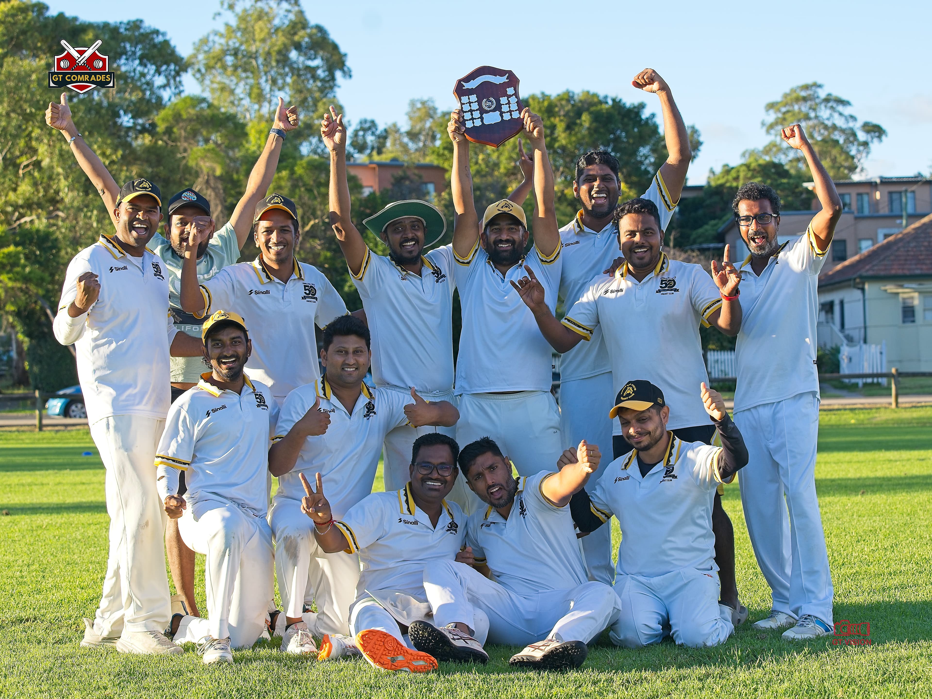 GT Comrades players celebrate together with a championship shield raised overhead
